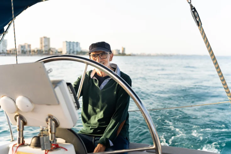 senior-skipper-steering-sailboat-in-coastal-waters-2025-08-11-16-20-31-utc
